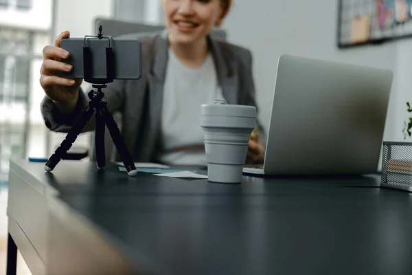 İş yerinde cep telefonu tutan gülümseyen güzel kadın. — Stok fotoğraf