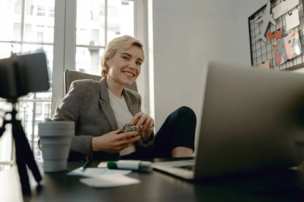 Mulher bonita feliz está sentado no local de trabalho — Fotografia de Stock