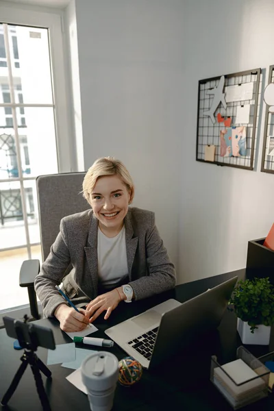 Happy pretty woman looking at camera in her office — 스톡 사진