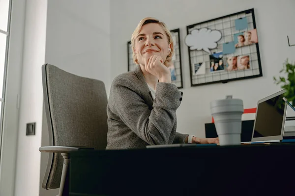 Usmívající se krásná žena dívá pryč v kanceláři — Stock fotografie