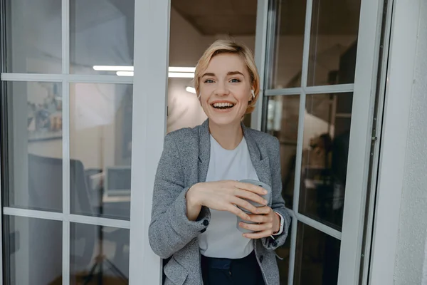 Happy pretty woman standing with hot drink — 스톡 사진