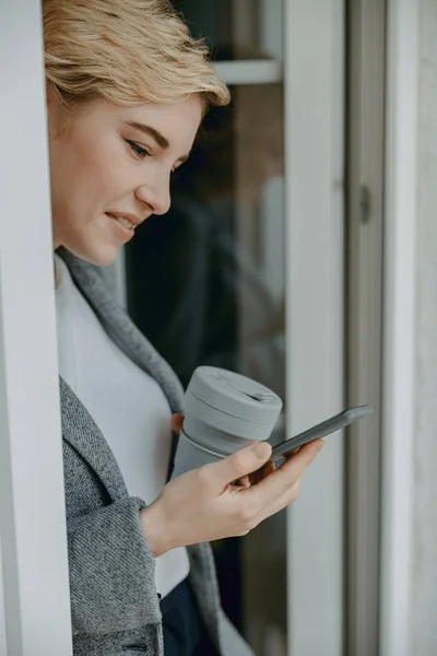 Sonriendo bonita dama leyendo mensajes en el teléfono inteligente — Foto de Stock