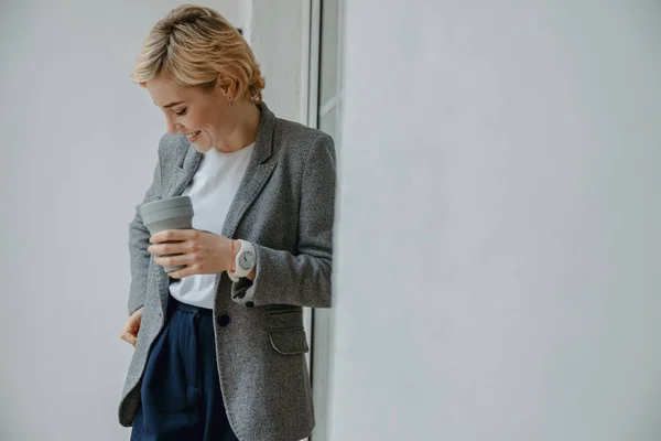 Happy young woman holding hot drink in hand — 스톡 사진