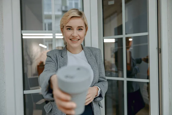 Young pretty woman posing with hot drink and smiling — 스톡 사진