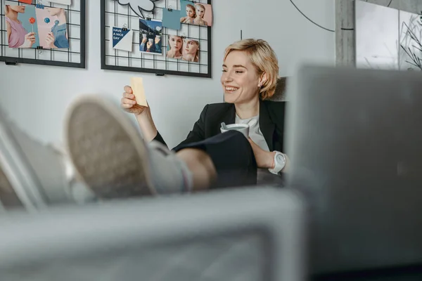 Smiling pretty woman looking on note at workplace — 스톡 사진