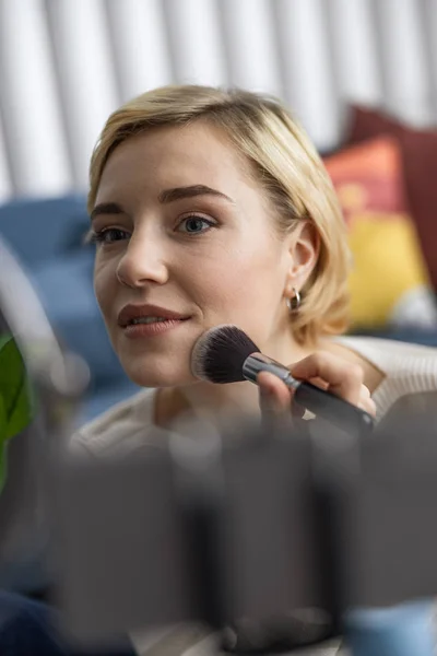 Smiling pretty lady doing makeup in living room — Stock Photo, Image