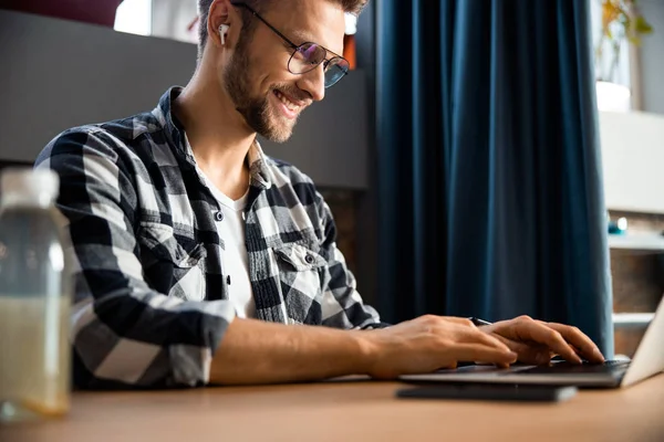 Sorridente bel ragazzo con computer portatile al caffè — Foto Stock