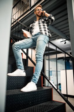 Mutlu genç adam korkuluklara yaslanıyor.