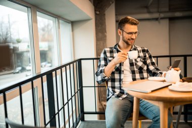 Telefondaki mesajları okuyan mutlu genç adam.