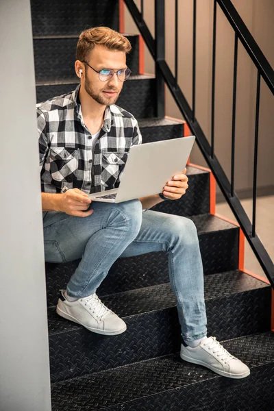 Freelancer masculino sentado com laptop nas escadas — Fotografia de Stock