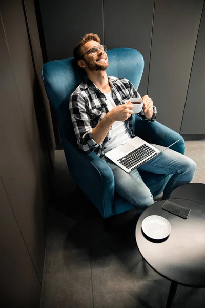 Mutlu genç adam bir fincan kahveyle dinleniyor. — Stok fotoğraf