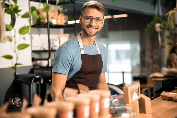 Beau barista debout au bar du café moderne — Photo