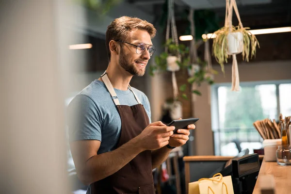 Happy male coffee shop owner standing at the counter — ストック写真