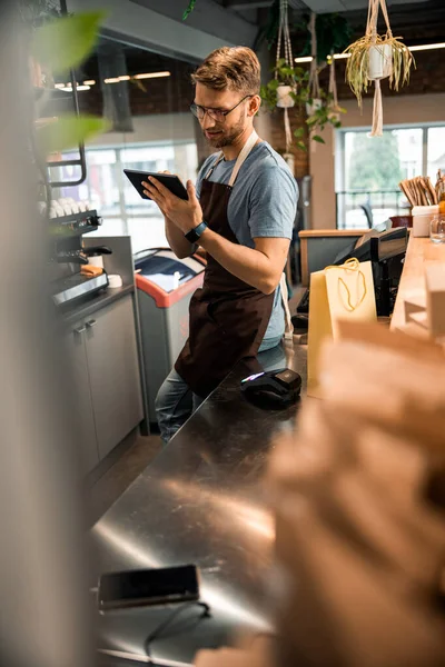 Щасливий чоловік власник кафе за допомогою цифрового планшета — стокове фото