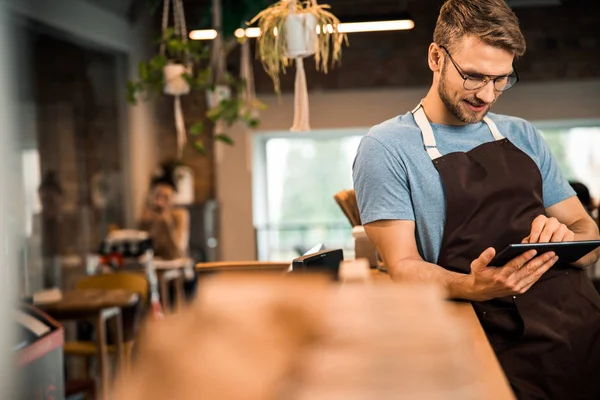 Jeune barista souriante penchée sur le comptoir du bar — Photo