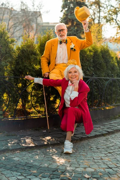 Happy senior woman near her husband in wearing funny accessories — Stockfoto