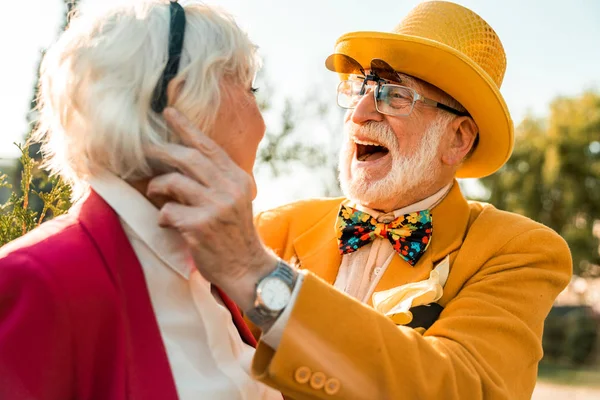 Veselý starší muž přizpůsobuje příslušenství své ženě — Stock fotografie