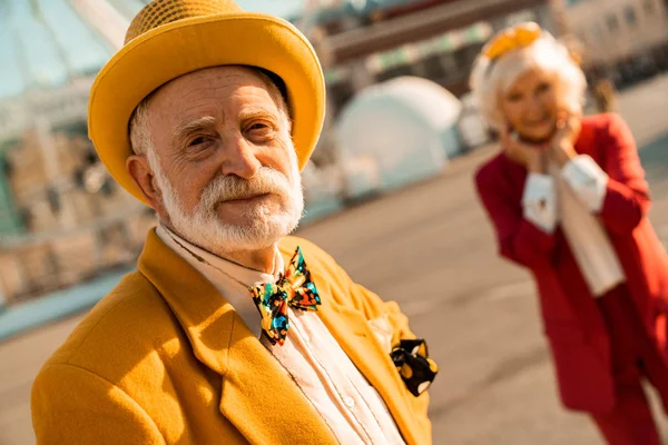 Sonriente anciano con sombrero mirando a la cámara al aire libre — Foto de Stock