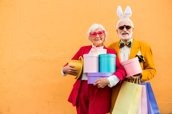 Lächelnde, fröhliche ältere Dame mit Hut und Schachteln — Stockfoto