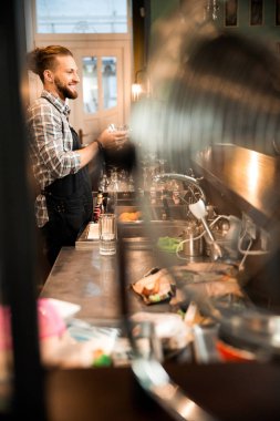 Gülümseyen barmen barda çalışıyor.