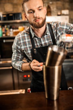 Barmen bardağa içki dolduruyor.