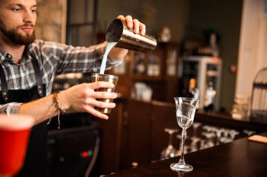 Profesyonel sakallı barmen tezgahta çalışıyor.