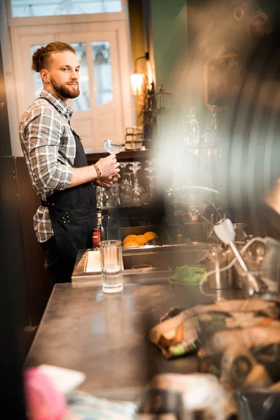 Профессиональный бармен держит пустой стакан в руках — стоковое фото