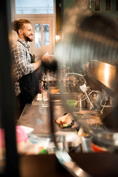 Gülümseyen barmen barda çalışıyor.