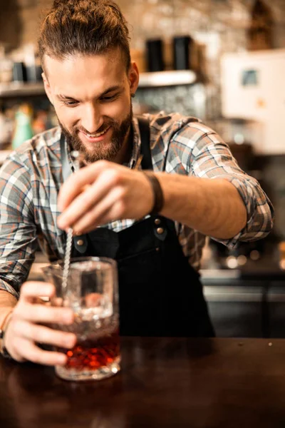 Barın içindeki mutlu barmen alkol kokteyli yapıyor. — Stok fotoğraf