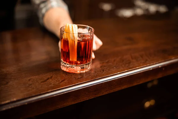 Fechar a mão do barman segurando um coquetel alcoólico — Fotografia de Stock