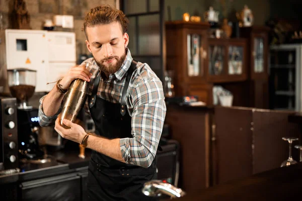 Lächelnd gutaussehender Barkeeper macht Cocktail im Shaker — Stockfoto