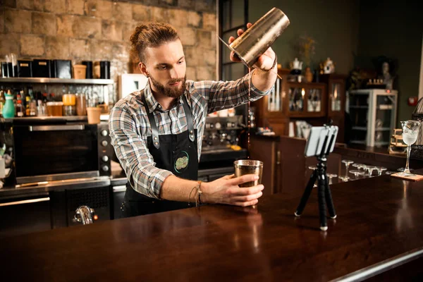 Barman barbudo sirviendo bebida de agitador — Foto de Stock