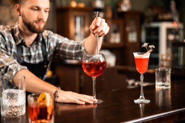 Genç barmen restoranda alkol kokteyli yapıyor.