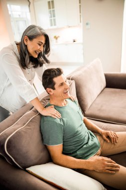 Mutlu, güzel bir eş, odada kocasının omuzlarında el ele tutuşuyor