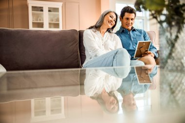 Mutlu yetişkin çift fotoğraf çerçevesi tutuyor.