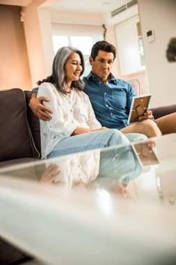 Birbirine aşık gülümseyen olgun bir çift birlikte fotoğrafçılığa bakıyor.