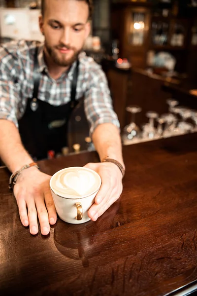 Mężczyzna barista dając kubek kawa dla klient — Zdjęcie stockowe