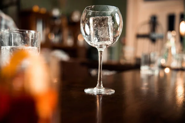 Empty clean glasses with ice at the bar counter — 스톡 사진