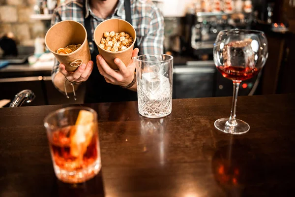 Young bartender is holding ingredients for cocktails — 스톡 사진