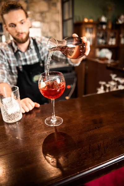 Profesjonalny barman wlewający koktajl do szklanki — Zdjęcie stockowe