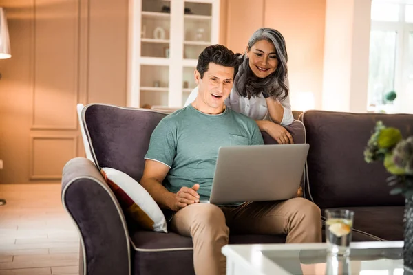 Felice uomo maturo utilizzando il computer portatile in soggiorno — Foto Stock