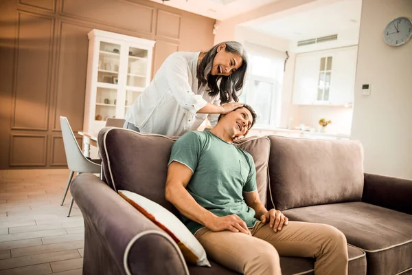 Smiling attractive wifw doing massage to her husband in room — Stock Photo, Image