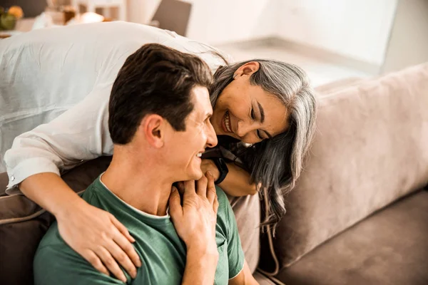 Glückliche schöne Frau umarmt ihren Mann zu Hause — Stockfoto