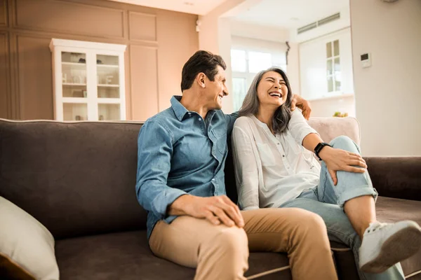 Mulher bonita feliz rindo com seu marido em casa — Fotografia de Stock