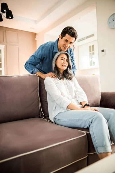 Sorridente marito massaggiare moglie spalle a casa — Foto Stock