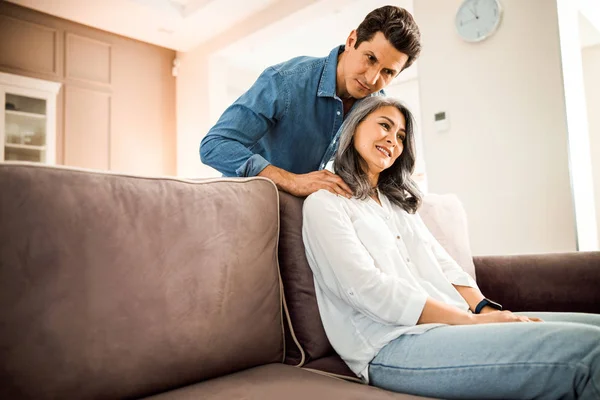 Sorridente marito maturo facendo massaggio alla sua bella moglie — Foto Stock