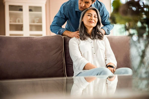 Beautiful wife enjoying massage from her husband at home — Stock Photo, Image