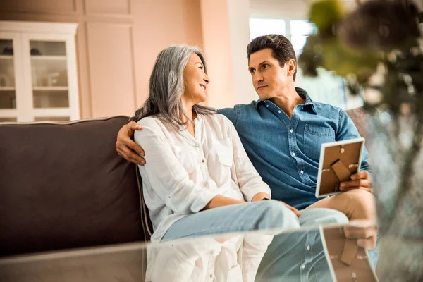 Happy adult man and woman looking each other in living room — Stock Photo, Image