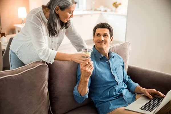 Smiling adult man taking glass of water from lady — Stock Photo, Image