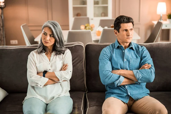 Membenci wanita dewasa duduk di sofa dan berpaling dari pria — Stok Foto